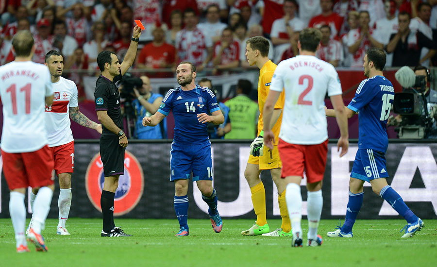 Referee Carlos Velasco Carballo (3rd left) shows Poland goalkeeper Wojciech Szczesny (3rd right) a straight red card
