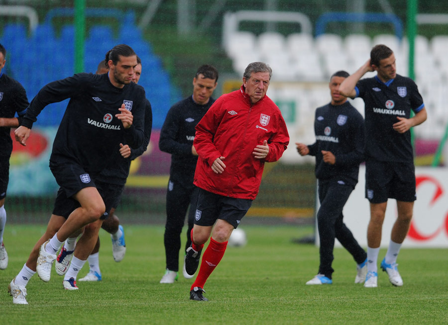 Andy Carroll trains alongside England manager Roy Hodgson