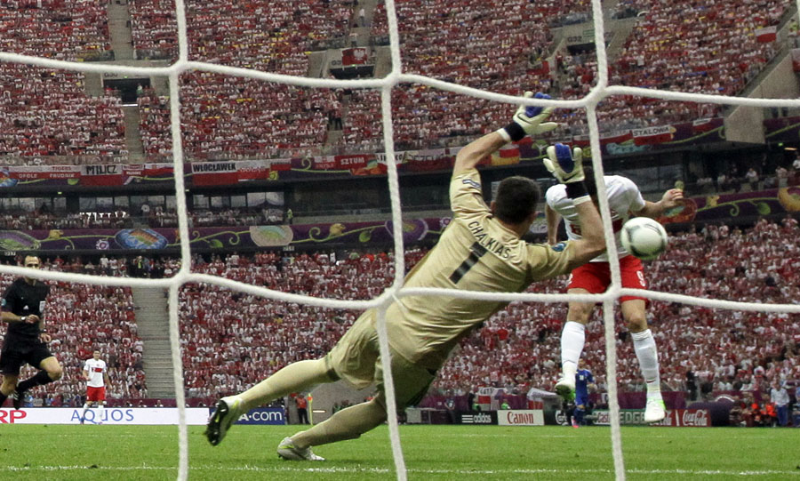 Robert Lewandowski scores a goal against Greece goalkeeper Costas Chalkias