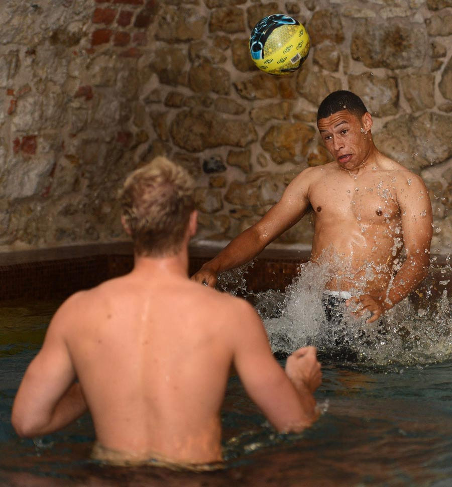 Alex Oxlade-Chamberlain heads a ball with Joe Hart