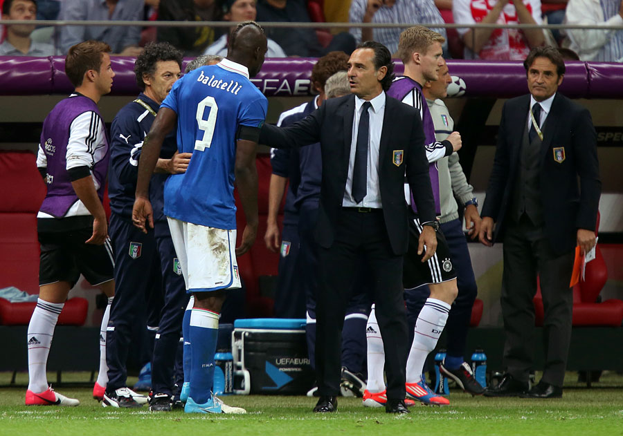 Italy's head coach Cesare Prandelli checks on the condition of Mario Balotelli after he picked up an injury