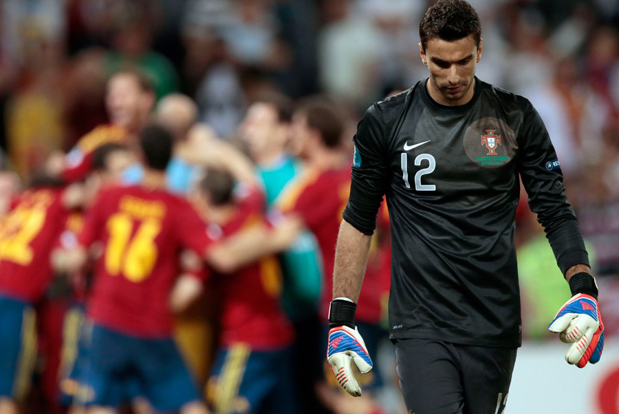 Portugal goalkeeper Rui Patricio walks past celebrating Spanish players following the defeat